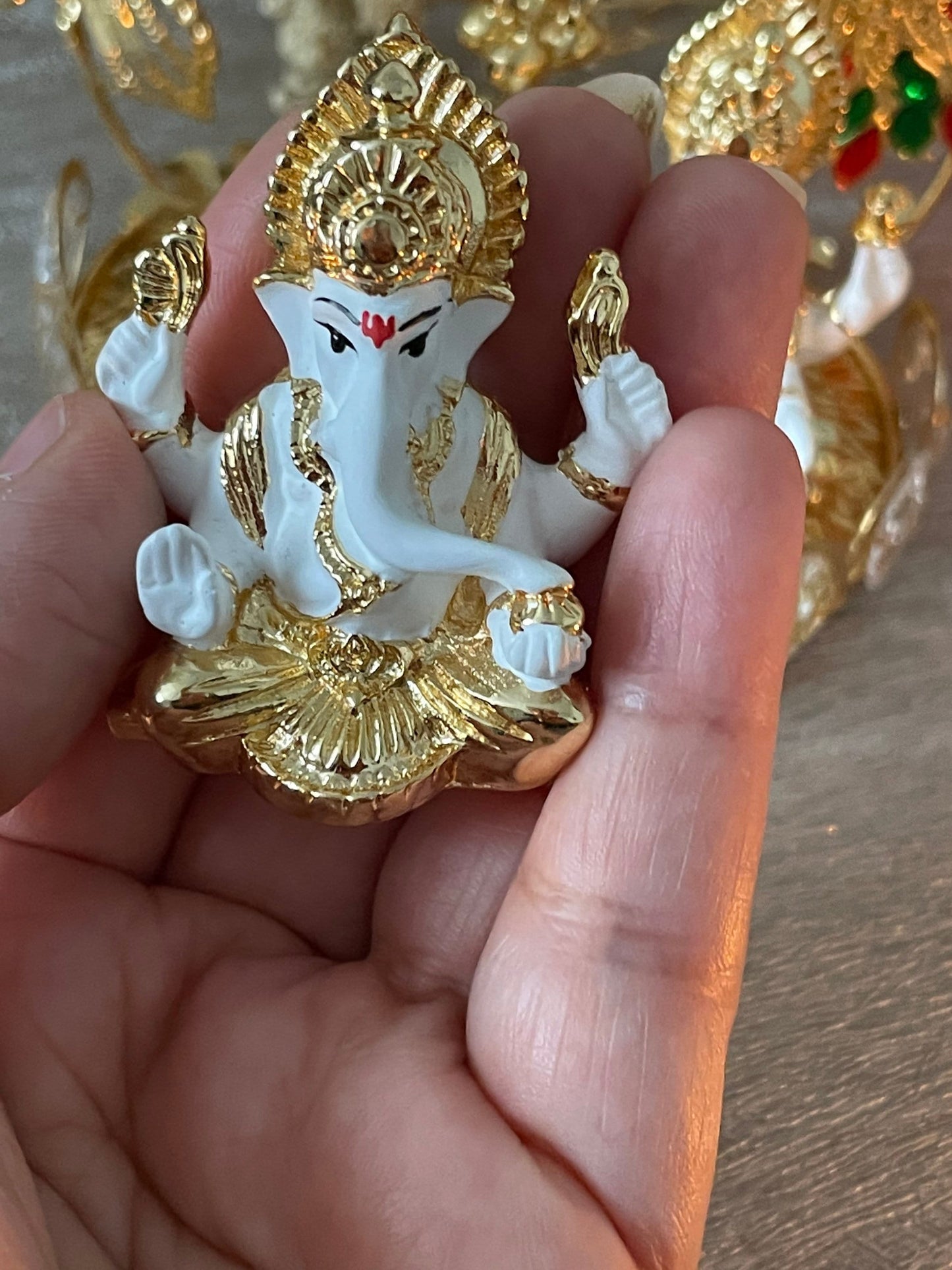Lakshmi and Ganesh Figurines Sitting on on a Metal Khaat White Figurines with Golden plating accents Diwali Pooja Gifting