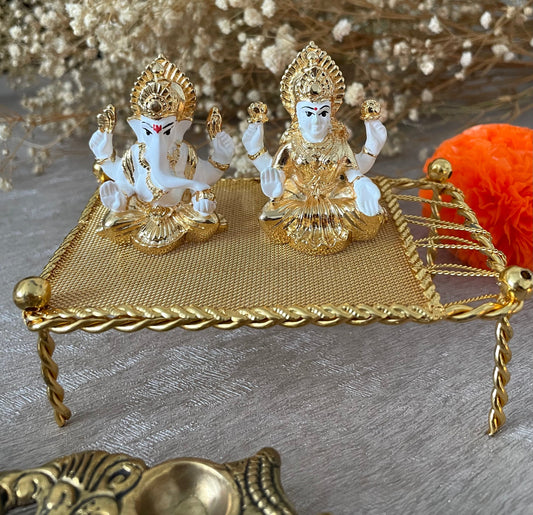 Lakshmi and Ganesh Figurines Sitting on on a Metal Khaat White Figurines with Golden plating accents Diwali Pooja Gifting