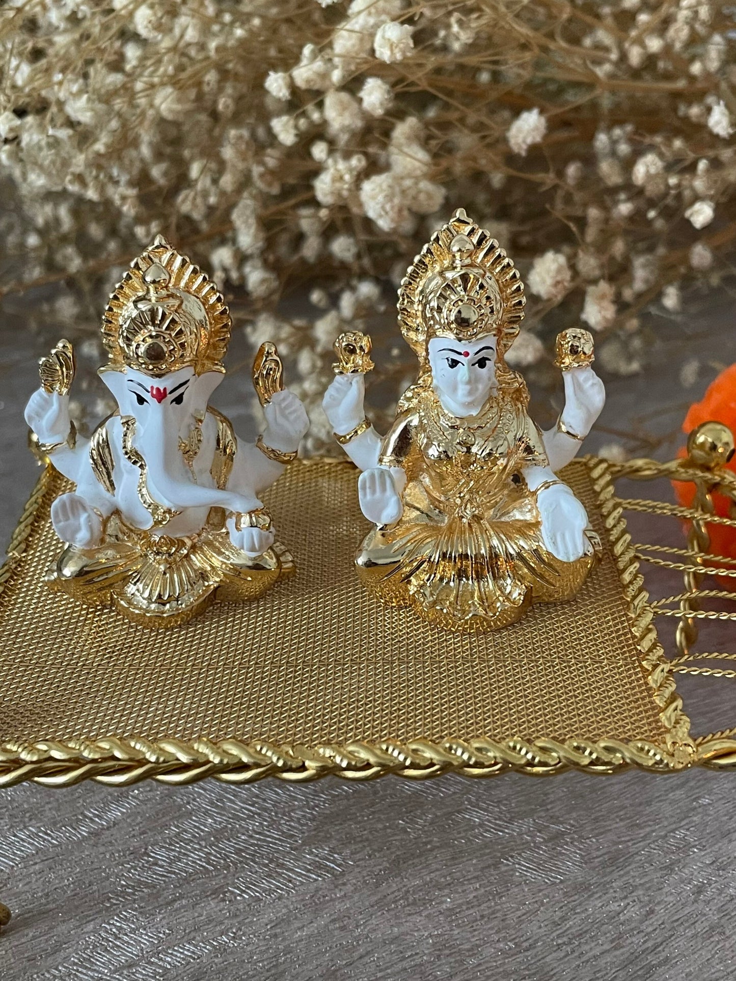 Lakshmi and Ganesh Figurines Sitting on on a Metal Khaat White Figurines with Golden plating accents Diwali Pooja Gifting